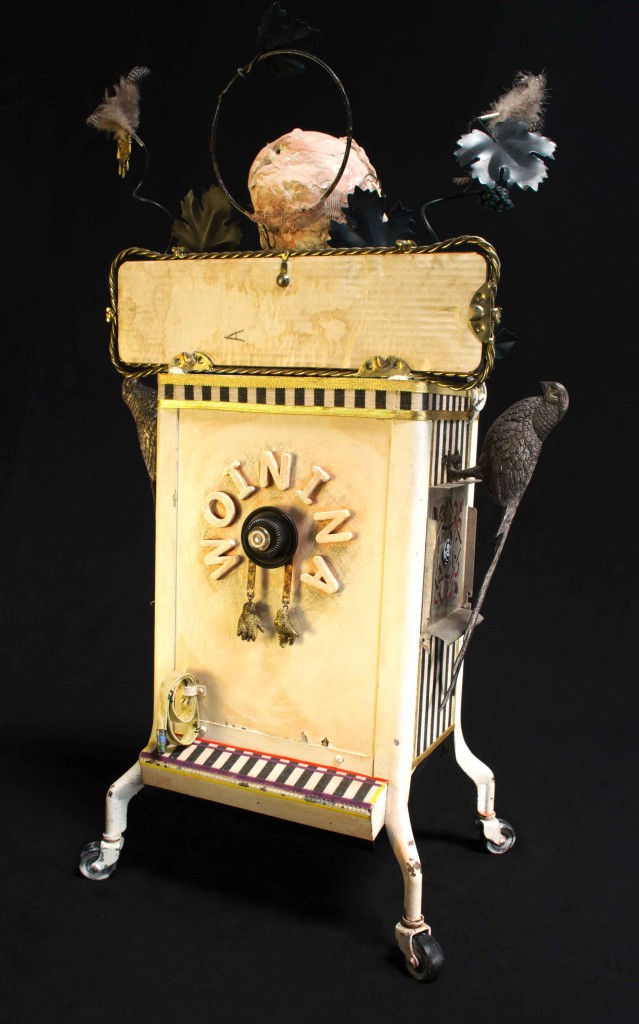 Woinina/ListenAndObserve (back view) assemblage with clay and found objects by Leslie Ann McQuaide, Assemblage with clay, mirror, antique soda bottle storage container, ediphone components, porcelain doll hands, vintage wire frame glasses, fabric, feathers, fur and other found objects 35 x 20 x 13 inches 2015